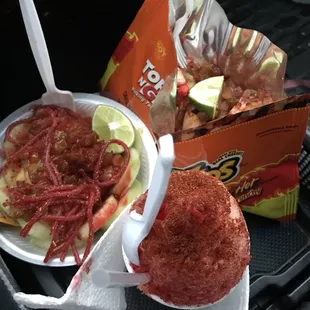 Sour cucumbers, hot Cheetos locos with pickles no hot cheese, and fruit punch snow cone with Chile