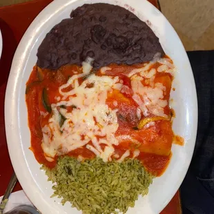Chicken enchilada with ranchero sauce and side of cilantro lime rice and black beans