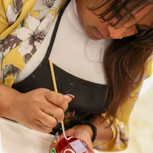 Artist Shawntay Customizing perfume bottles.