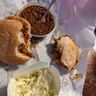 Chicken sandwich (left) and brisket sandwich (right) with slaw and beans as sides.