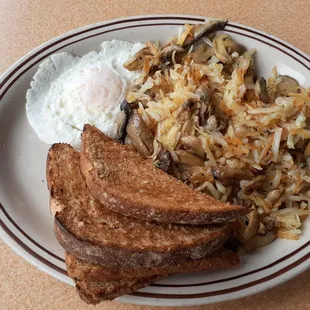 One egg over easy, hash browns with mushrooms, wheat toast, and a large tomato juice.