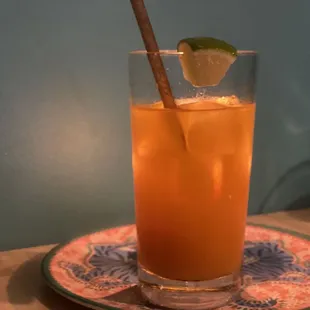 a glass of orange juice on a plate