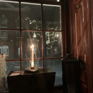 a lit candle on a window sill