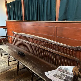 a wooden bench with a newspaper on it