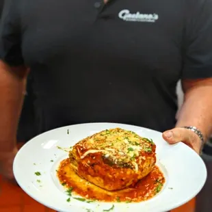 a man holding a plate of lasagna