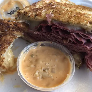 a roast beef sandwich with a side of mustard