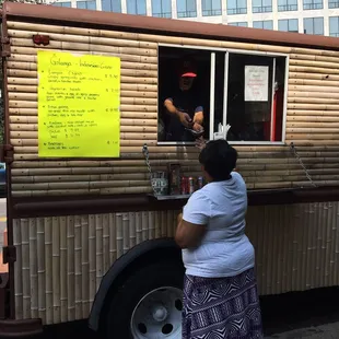 a woman ordering food from a food truck