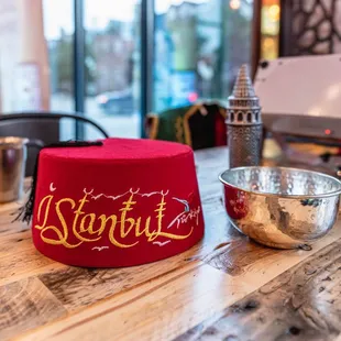 a red hat and a bowl on a wooden table