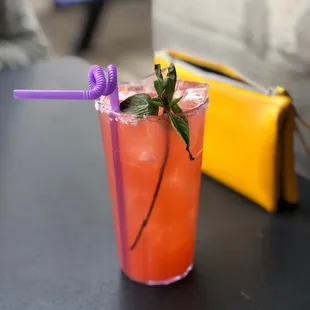a drink in a glass with a straw and a purple straw