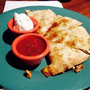 Chicken quesadilla with salsa and sour cream.