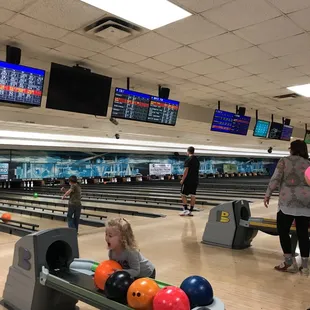 a little girl playing bowling