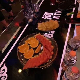 Watermelon and orange slices as well as potato chips