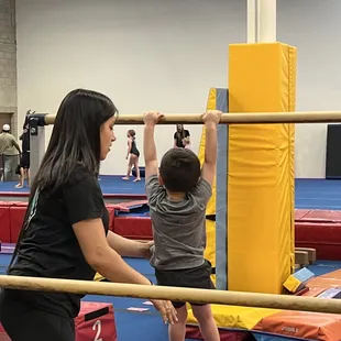 Hanging off the uneven parallel bars. They have different stations that teach all the pre-skills.
