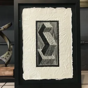 Floated art on black mat, glazed with museum glass and blk frame.