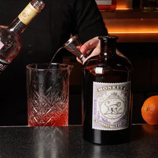 a bartender pouring a drink into a glass
