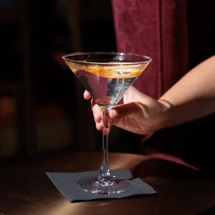 a person holding a martini glass