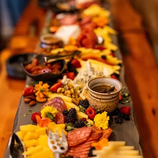a platter of cheese, fruit, and meats
