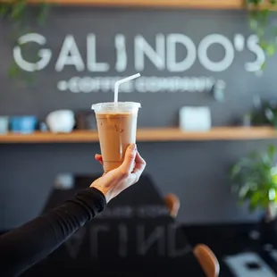 a hand holding a cup of coffee