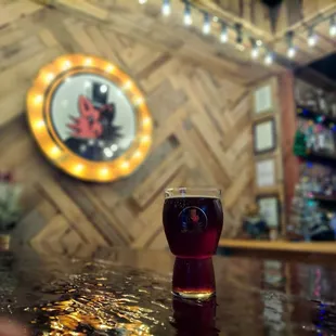 a glass of beer on a bar
