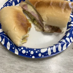 a half eaten sandwich on a blue and white plate