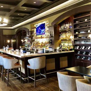 a bar with chairs and a television