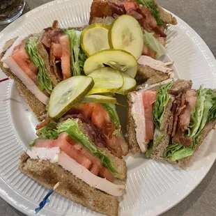 a plate of sandwiches with pickles and cucumbers