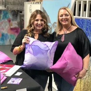 Artist Ginger Walker (r) poses with Scott + Martin's new pillow covers and decorative clutches at a recent open house!