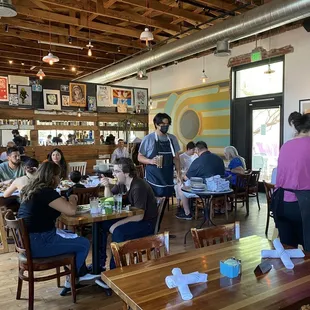 a group of people sitting at tables in a restaurant