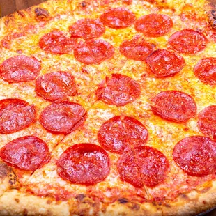 a pepperoni pizza on a wooden table