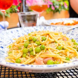 a plate of pasta with peas and ham