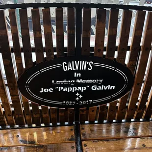 a wooden bench with a sign on it