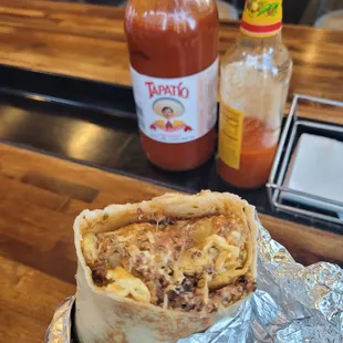 Sausage, egg, and cheese breakfast burrito with potatoes and salsa.