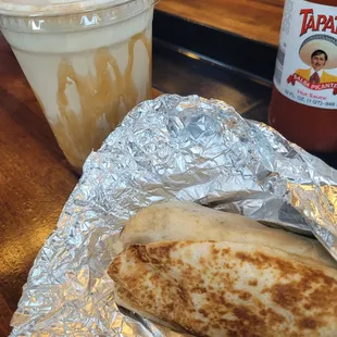 Sausage, egg, and cheese breakfast burrito with potatoes and salsa. Medium iced machiatto.