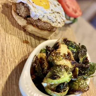 a plate of brussels sprouts and a burger