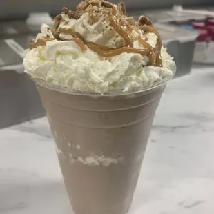 a milkshake topped with whipped cream and caramel