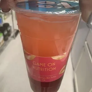 a hand holding a cup of juice