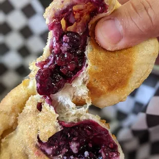 a hand holding a half eaten pastry