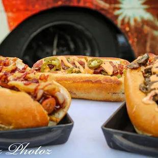 three hot dogs with toppings