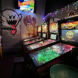 a row of pinball machines in a dark room