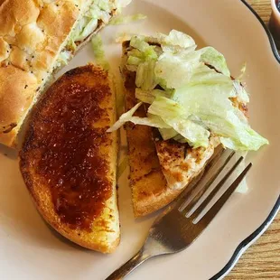 Cajun chicken sandwich sparsely dressed with iceberg lettuce only.
