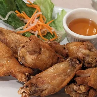 a plate of chicken wings and a side of salad