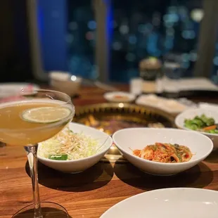 a table with plates of food and a glass of wine
