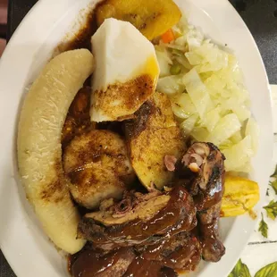 Jerk chicken with sweet cabbage, fried plantains, and provisions.