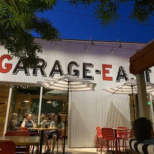 people sitting at tables under umbrellas
