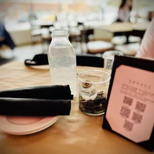 a table with a bottle of water and a menu