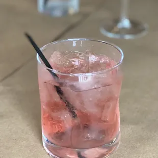a pink drink with ice