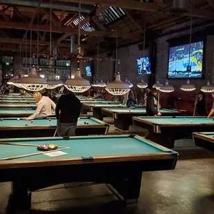 people playing pool in a large room