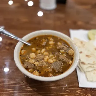 a bowl of soup and a tortilla