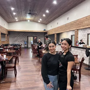 two women standing in a restaurant