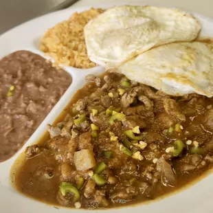 Bistec Ranchero topped with fresh chile, eggs, rice, and beans